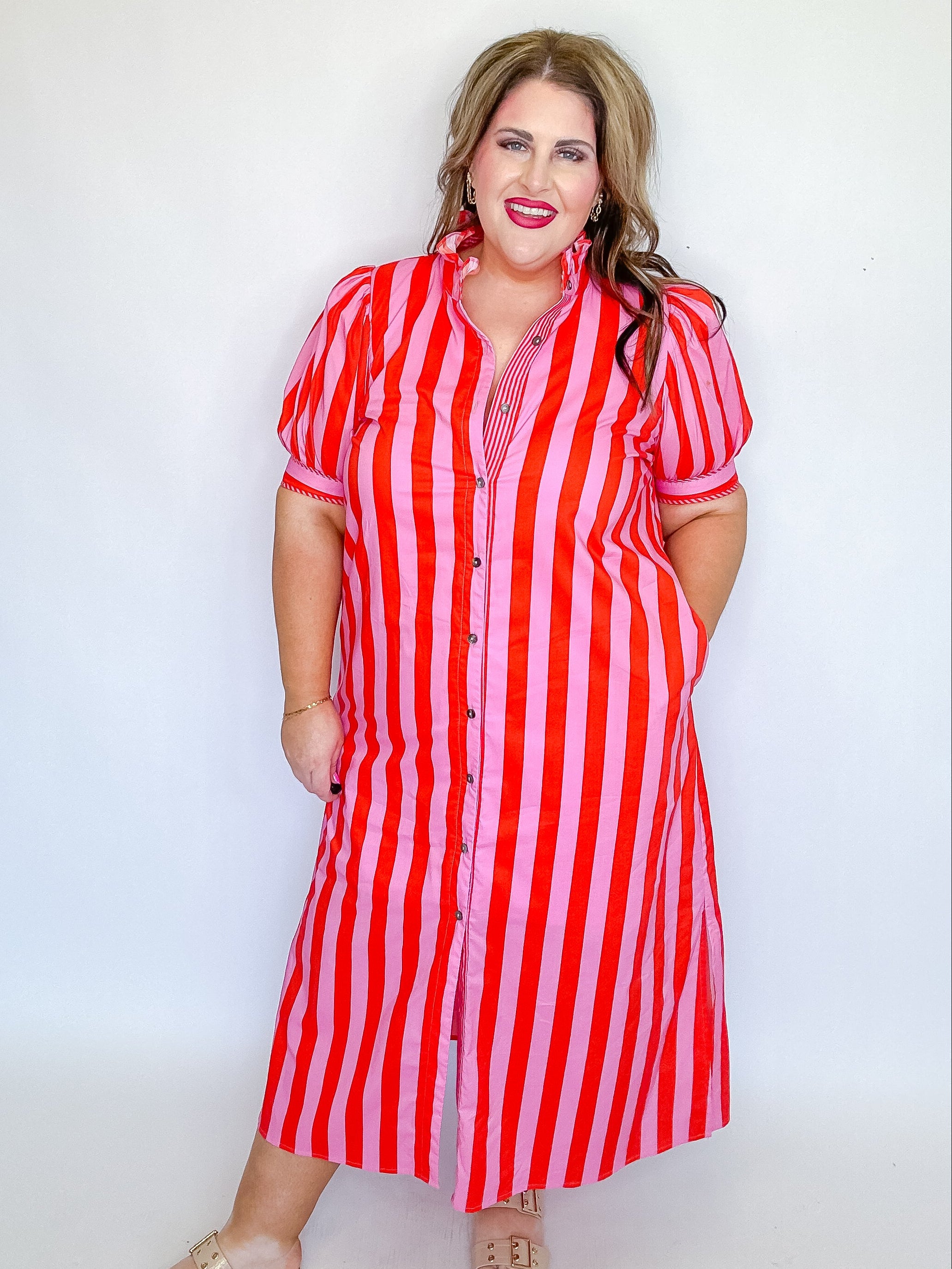 Woman wearing a red and white striped dress against a plain background
